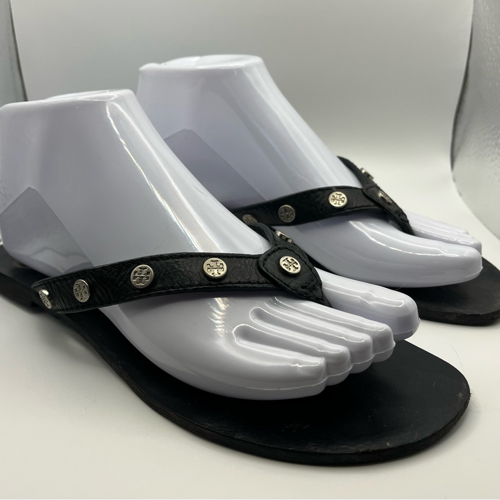Tory Burch textured black leather flat thong sandal with silver logo studding.